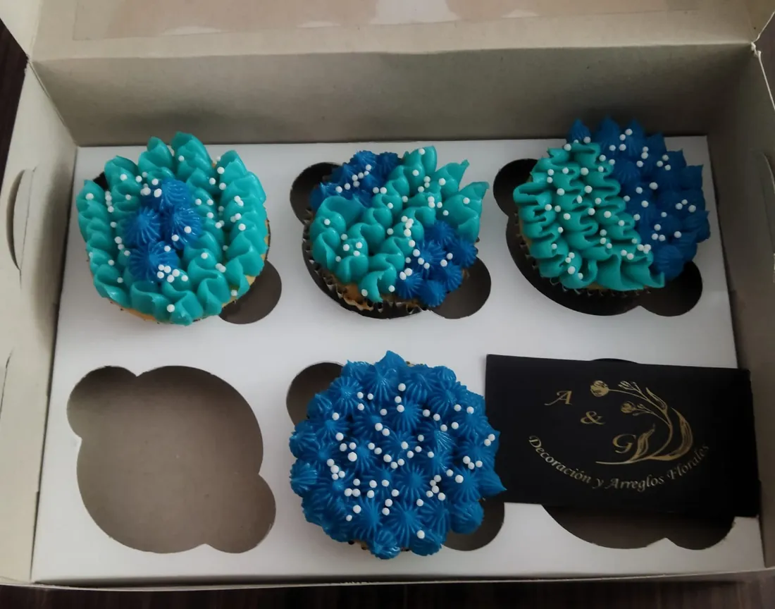 Caja de cupcakes con betún azul y perlas de azúcar